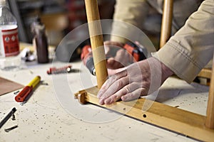 Man repair old wooden chair