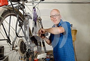 Man repairing bicycle in his workshop.