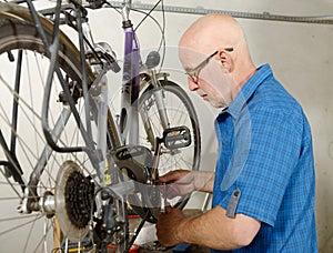 Man repairing bicycle in his workshop.