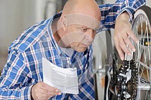 Man repairing bicycle at home