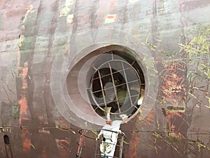 Man repairing bow thruster of huge vessel