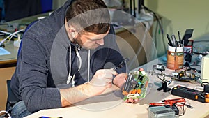 Man repairing broken device in workshop