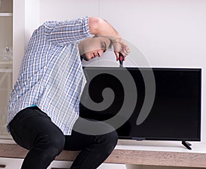 Man repairing broken tv at home