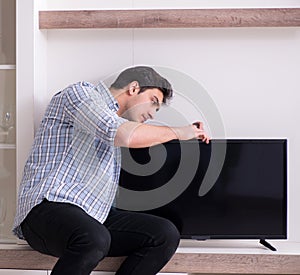 Man repairing broken tv at home