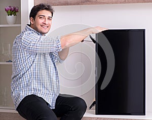 Man repairing broken tv at home