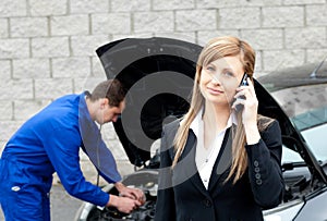 Man repairing car of a businesswoman