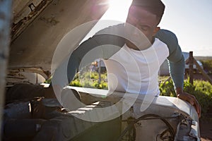 Man repairing car at countryside