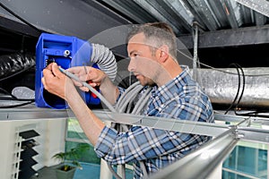 Man repairing ceiling ventilation