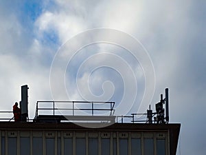 Man Repairing Cellphone Repeaters On a Roof