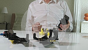 A man is repairing a coffee-making unit of a coffee machine, repair shop of coffee makers