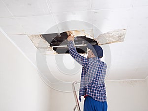 Man repairing collapsed ceiling.