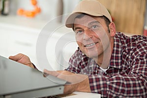 man repairing domestic oven in kitchen