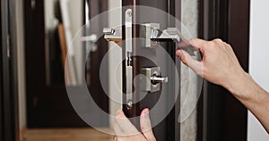 a man repairing a door knob. locksmith fixing a wooden door.