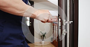 a man repairing a door knob. locksmith fixing a wooden door.