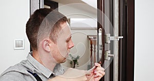 a man repairing a door knob. locksmith fixing a wooden door.