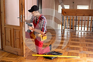 Man repairing door lock. Hand of the repairman with a screwdriver