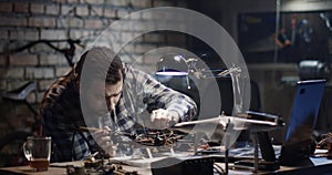 Man repairing a drone in a garage