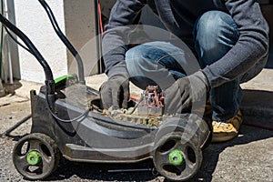 Man repairing an electric lawn mower