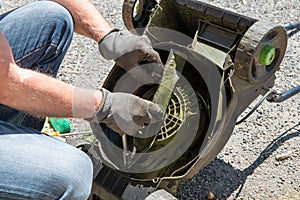 Man repairing an electric lawn mower