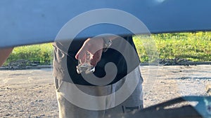 man repairing the engine of his old car during the day