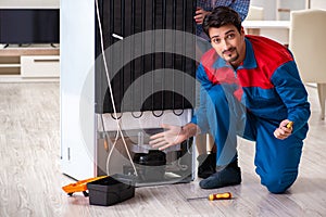 The man repairing fridge with customer