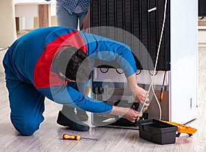 Man repairing fridge with customer