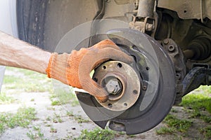 Man is repairing front suspender of a car