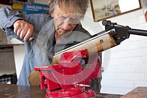 Man repairing a gun in his workshop