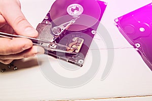 Man repairing hard disk. Inside details of the old personal computer. Broken PC.  Pincers in hands