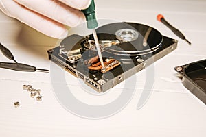 Man repairing hard disk. Inside details of the old personal computer. Broken PC.  Screwdriver in hands