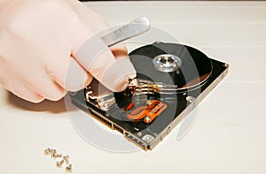 Man repairing hard disk. Inside details of the old personal computer. Broken PC.  Screwdriver in hands