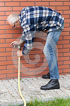 Man repairing leaky garden hose spigot