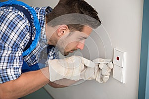 Man Repairing Light Switch At Home