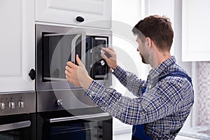 Man Repairing Microwave Oven