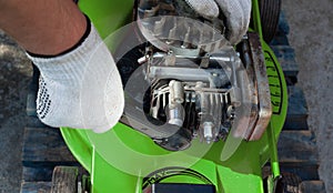 Man repairing an old lawn mower, gas engine.