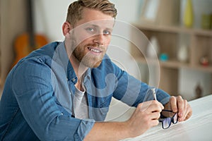 man repairing pair spectacles with screwdriver