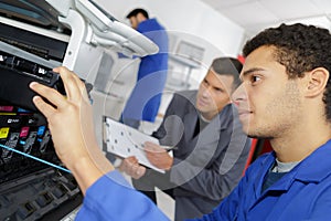 Man repairing printer in professional school