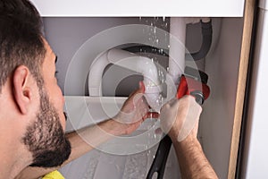 Man Repairing Sink Pipe Leakage