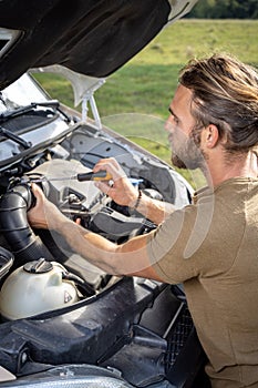 Man repairing a van outdoors