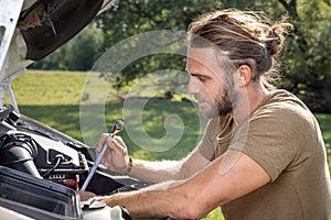 Man repairing a van outdoors in nature