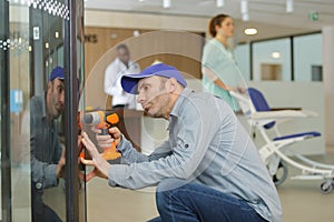 man repairing vending machine using screwdriver in hospital