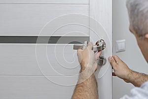 Man changing the door lock at home