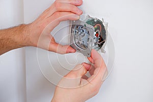 A man repairs a lighting switch. Close-up on hand. Electrician work
