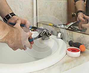 a man repairs an old faucet in the bathroom