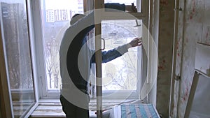 Man repairs wood window. Replace broken glass on window