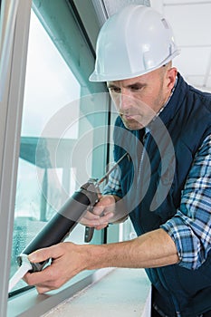 man replacing building window