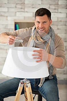 man replacing bulb in lamp