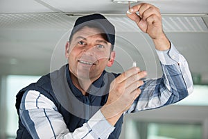 Man replacing ceiling light bulb