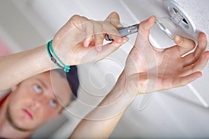 Man replacing spotlight in ceiling