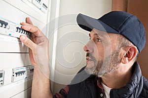 Man resetting switch in circuit breaker cabinet photo